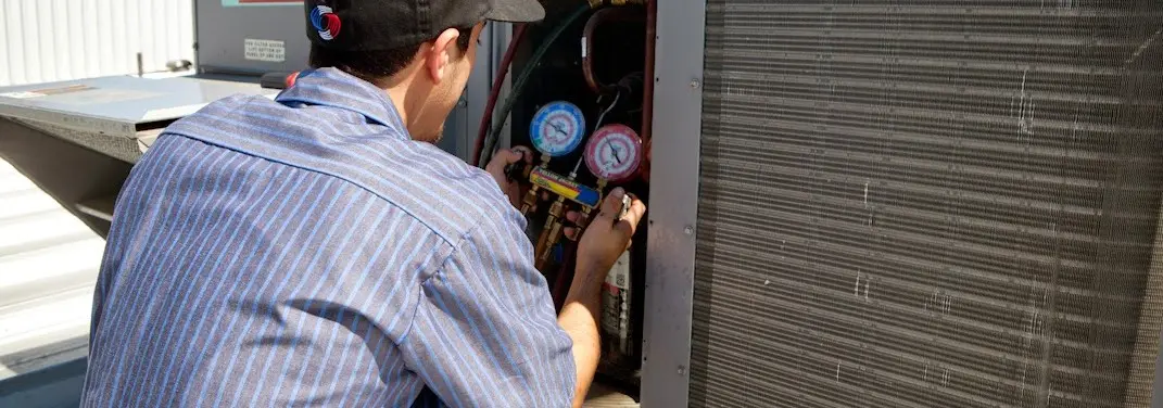 HVAC technician servicing a condenser unit in Stuarts Draft