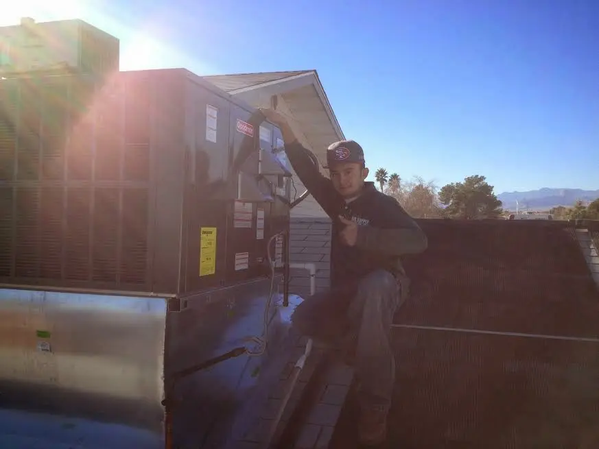 HVAC technician performing Air Duct Cleaning on a rooftop unit in Stuarts Draft